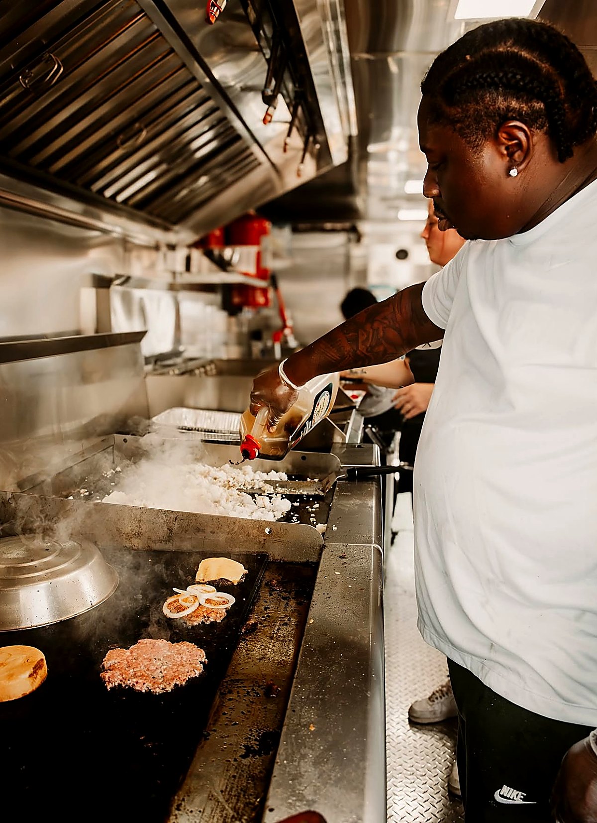 Smash patties on the griddle inside the truck
